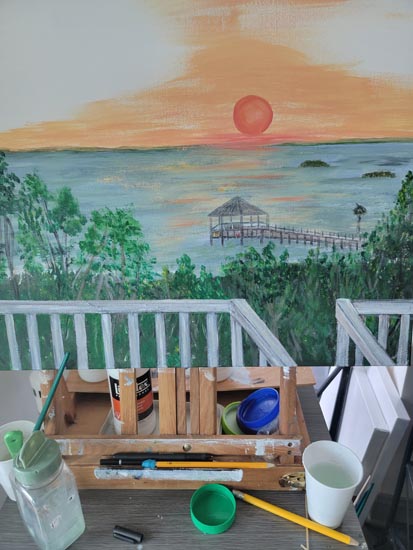 Painting on easel with paint and brushes in foreground